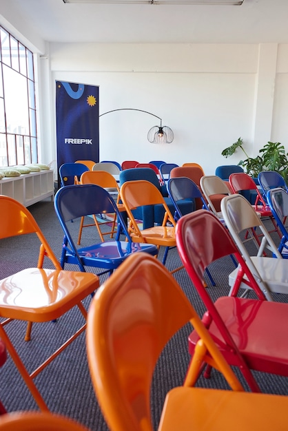 Colorful folding chairs arranged with Freepik banner